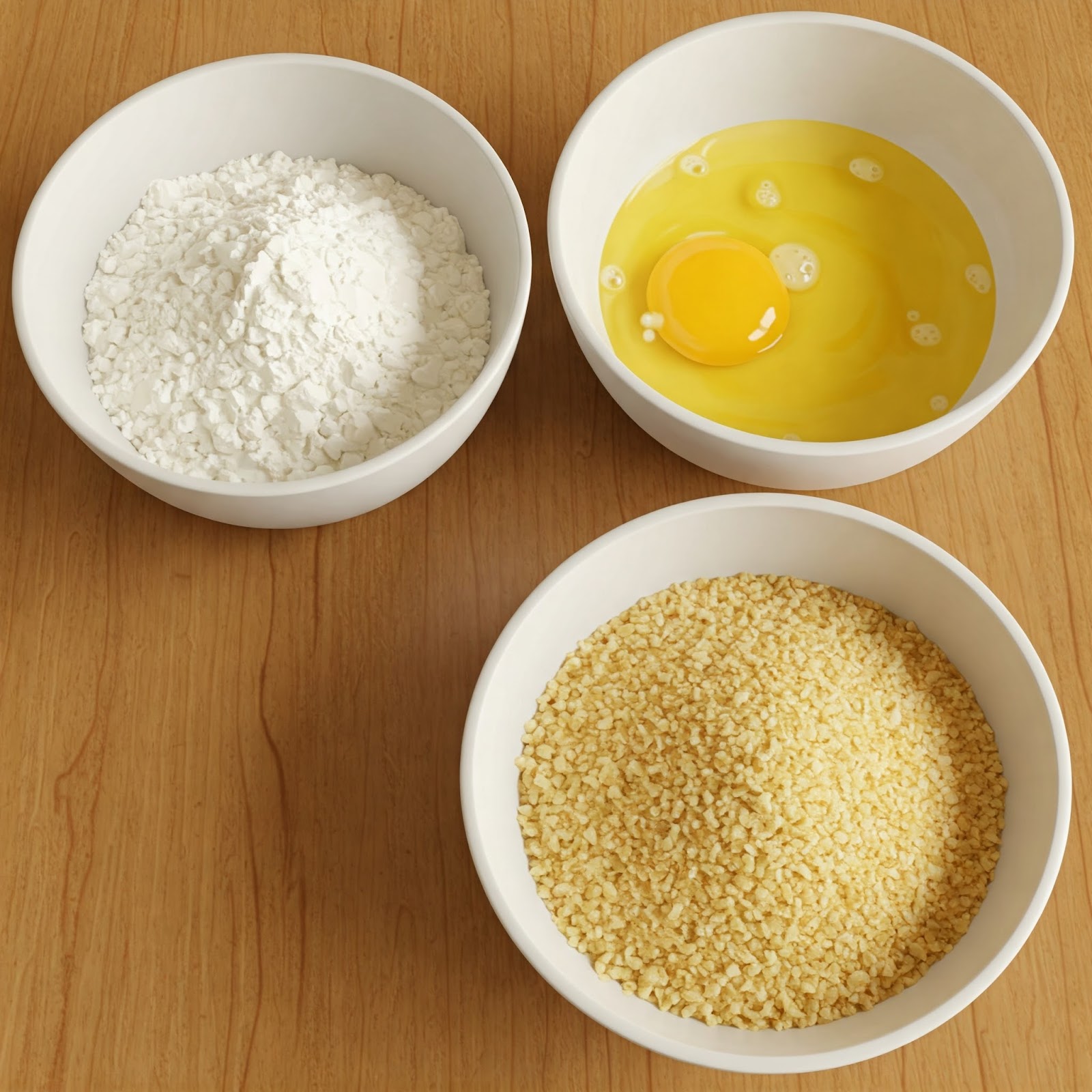 3 bowls set on the table to bread raw pork cutlet. One filled with eggs, another with flour and the third one with bread crumbs.