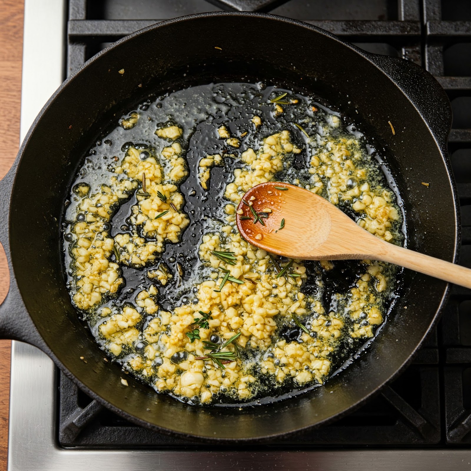 chopped garlics being sautéed in butter with mixed herbs