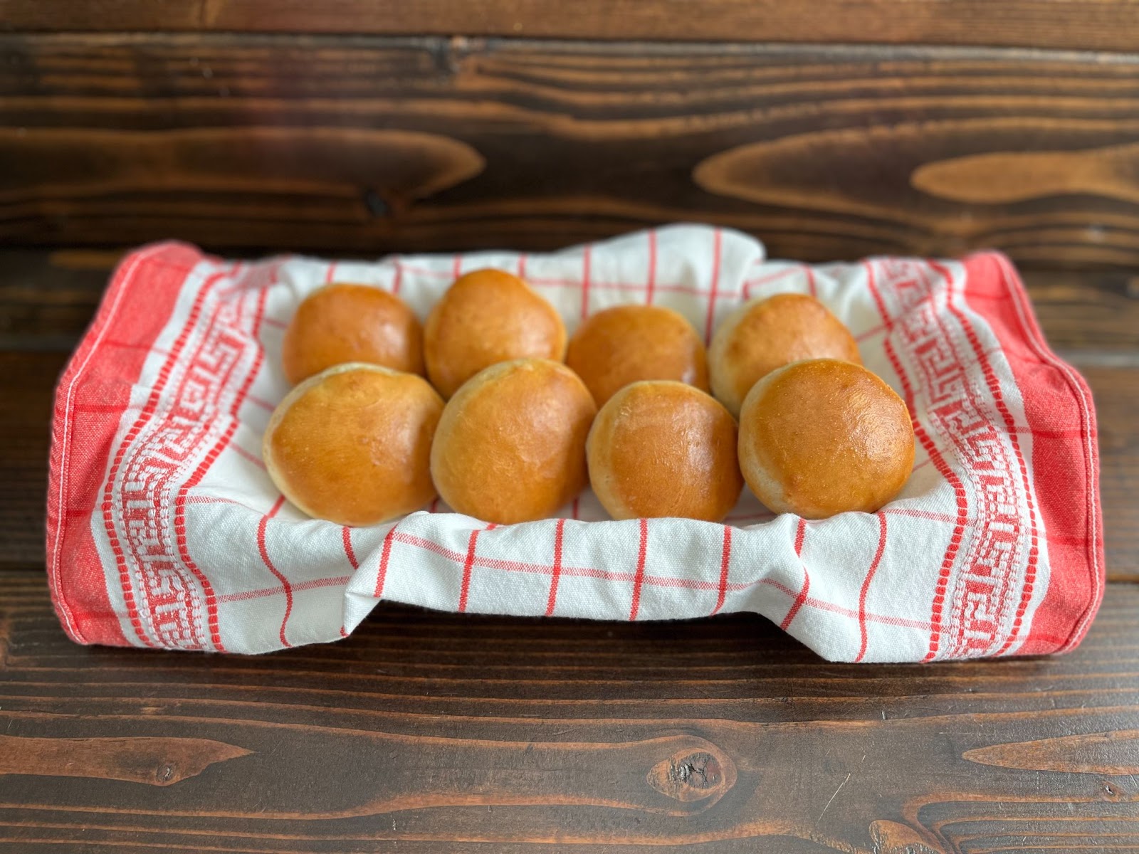 Potato Rolls kept on towel placed in a basket on a wooden table top