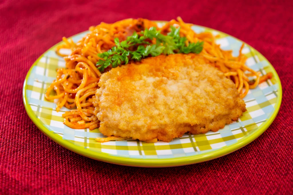 cutlet with pasta being served in a plate