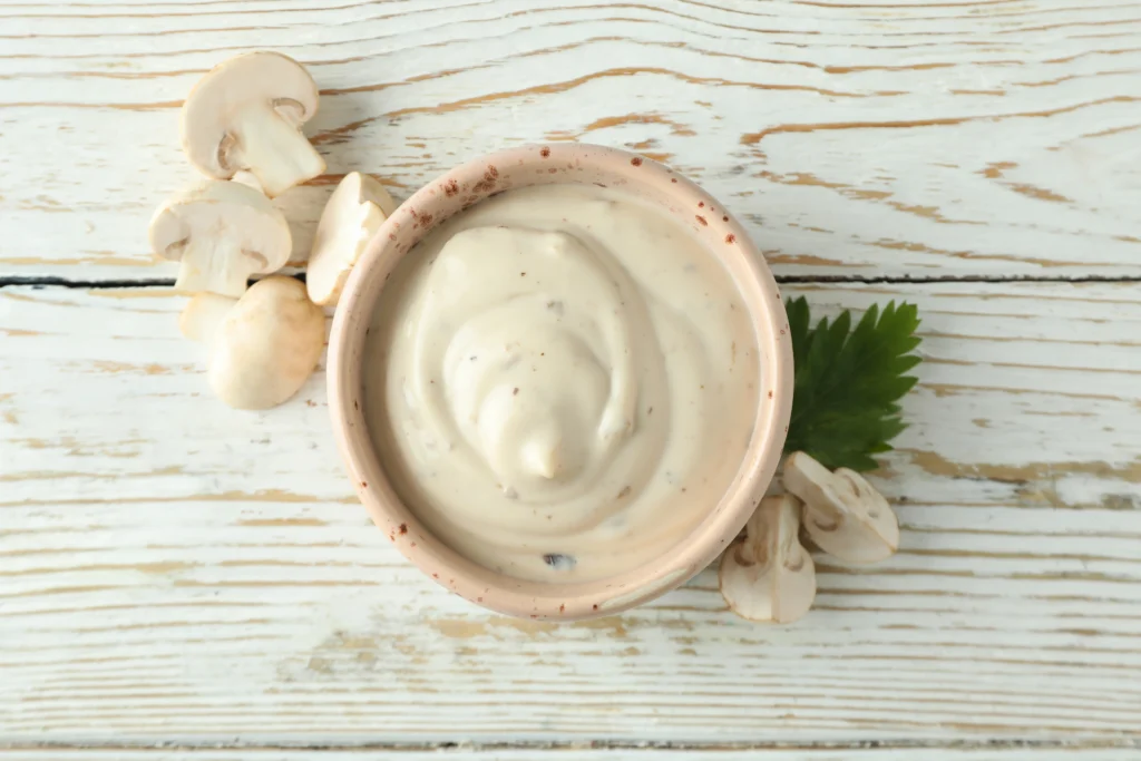 creamy mushroom sauce served in a bowl placed on wooden table