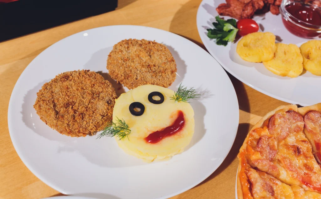 Playful plate with smiley face food and air fryer cutlets for kids