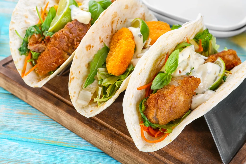 chicken tacos placed on wooden board