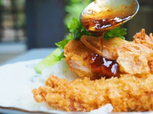 honey-sauce-being-poured-on-cutlet