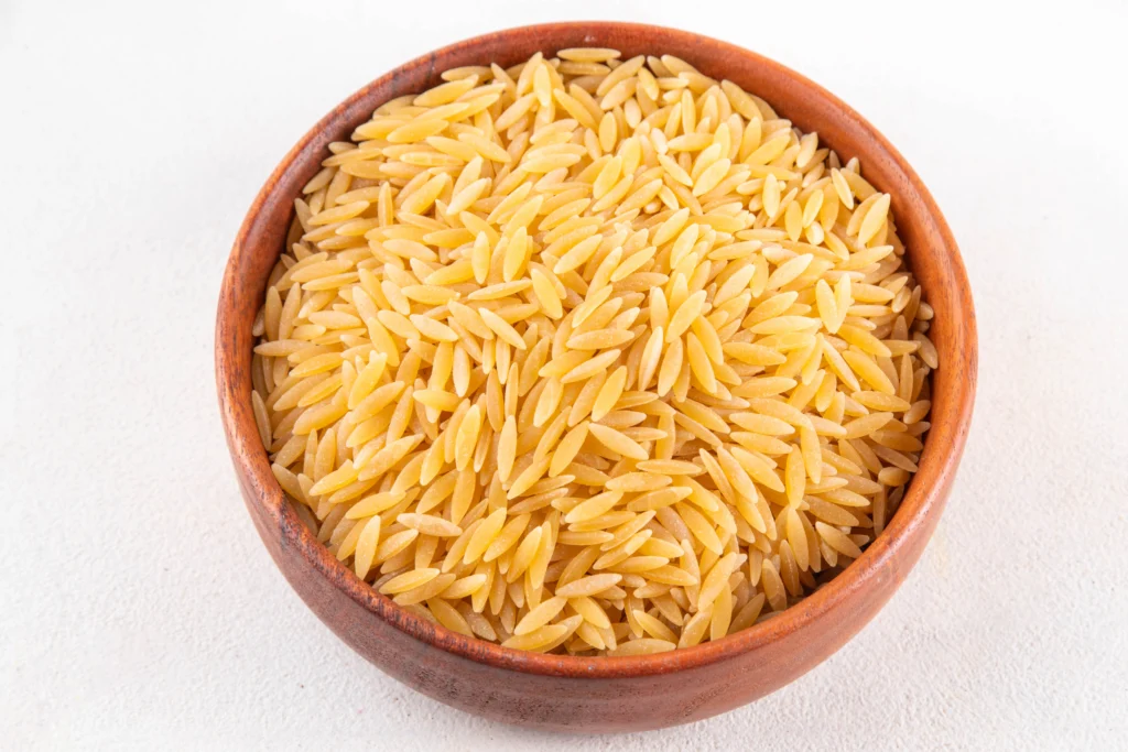 raw uncooked orzo pasta in a brown bowl
