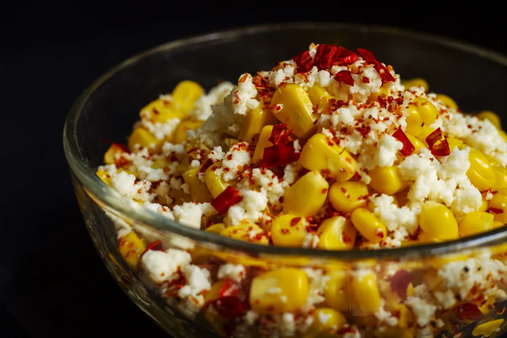 elote salad served in a bowl with cotija cheese and paprika powder on top